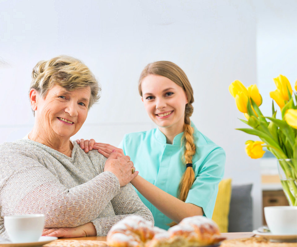 caregiver and senior woman are smiling