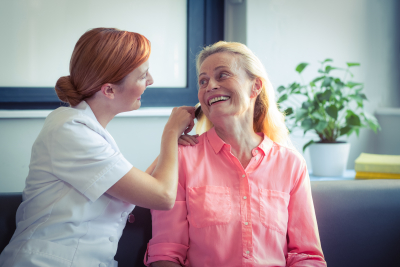 caregiver combing the hair of the senior woman